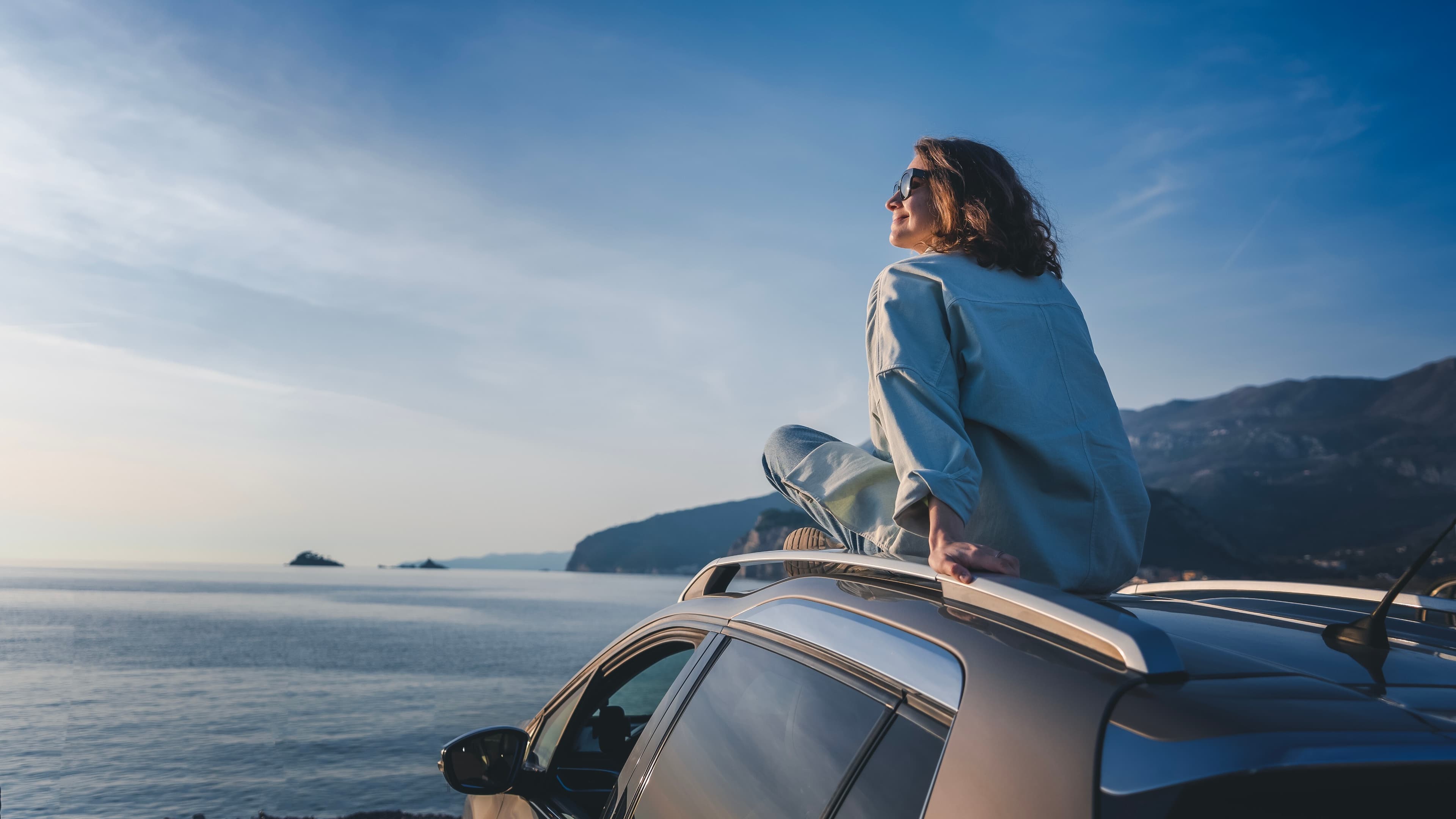 Passagers dans un SUV décapotable sous un ciel bleu